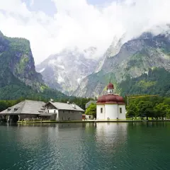 St. Bartholomä Kirche am Königssee, ein malerisches Ziel für Ausflugsziele Berchtesgaden, vor imposanter Bergkulisse.