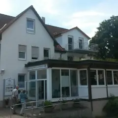 Wald-Gaststätte zum Schillerstein in Blaubeuren. Zwei Gäste betreten das Gasthaus.