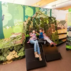 Familie erkundet im Naturparkzentrum Zaberfeld eine Wald-Ausstellung mit interaktiver Hütte.