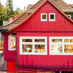 Ein leuchtend rotes Haus mit Holzbrücke und bunten Bändern. Hier gibt es Spaß für eins und alles ab welchem Alter.