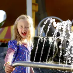 Ein fröhliches Mädchen spielt am Wasserspielplatz im Europa-Park.