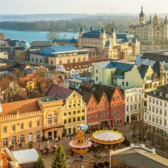 Blick über Schwerin mit Schloss, Rathaus und bunten Giebelhäusern. Entdecken Sie Schwerin Geheimtipps für Ihren nächsten Besuch!