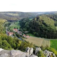 Idyllisches Lautertal Alb mit kleinen Dörfern, Flüssen und bewaldeten Hügeln, aufgenommen von einem Felsvorsprung.
