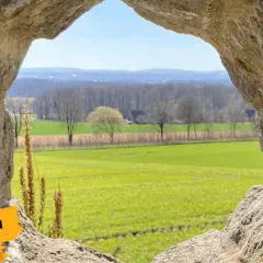 Blick durch eine Felsöffnung auf grüne Felder und Bäume. Ein tolles Motiv für Ausflugsziele Niederrhein, um Kindern die Welt zu zeigen.