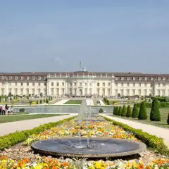 Prachtvolles Barockschloss Ludwigsburg mit symmetrischen Gärten und einem blühenden Blumenbeet vor einem Brunnen.