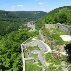 Ruinen der Burg Hohenwittlingen, umgeben von grünen Wäldern, mit einem Dorf im Tal.