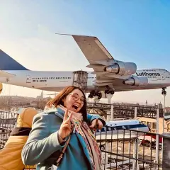 Fröhliche Frau vor einem Jumbo-Jet im Technik Museum Speyer. Ein spannender Ausflug in die Welt der Luftfahrt.