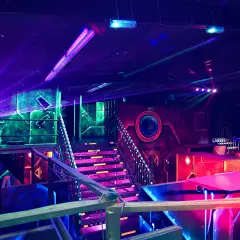 Futuristische Halle mit bunten Lichtern und Lasern. Ein aufregender Ort für Schwarzlicht Minigolf in Heidelberg.
