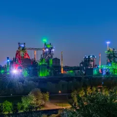 Industriepark Landschaftspark Nord in Duisburg bei Nacht, beleuchtet in bunten Farben. Ein toller Ort, um zu sehen, was man in Duisburg machen kann!
