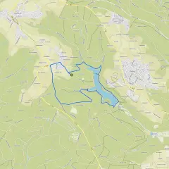 Der Herrenbachstausee mit seiner Kugelbahn-ähnlichen Uferlinie, eingebettet in grüne Hügel und Wälder.