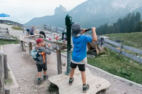 Kinder spielen am Juwelenweg Pfronten mit Bergpanorama.