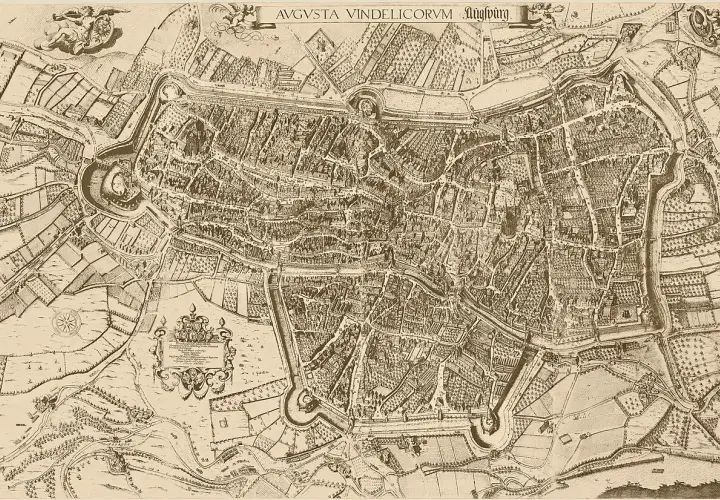 Historische Ansicht der Stadt Augsburg mit ihrer imposanten Burg und Stadtmauern, umgeben von Feldern und Wasserwegen.