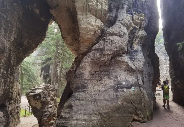 Ein schmaler Pfad führt durch das Felsenlabyrinth Blaubeuren, vorbei an imposanten Felsformationen und Bäumen.