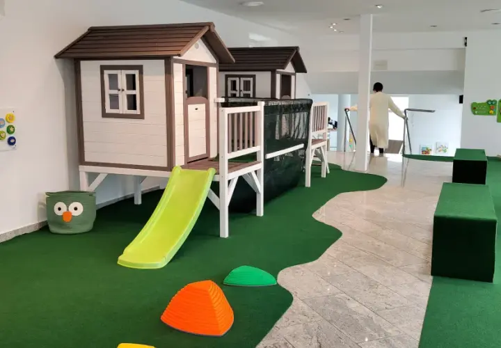 Einladendes **Cafe mit Spielplatz**: Zwei Spielhäuser mit Rutschen, Klettergerüst, Spielzeug und Sitzgelegenheiten für Kinder.