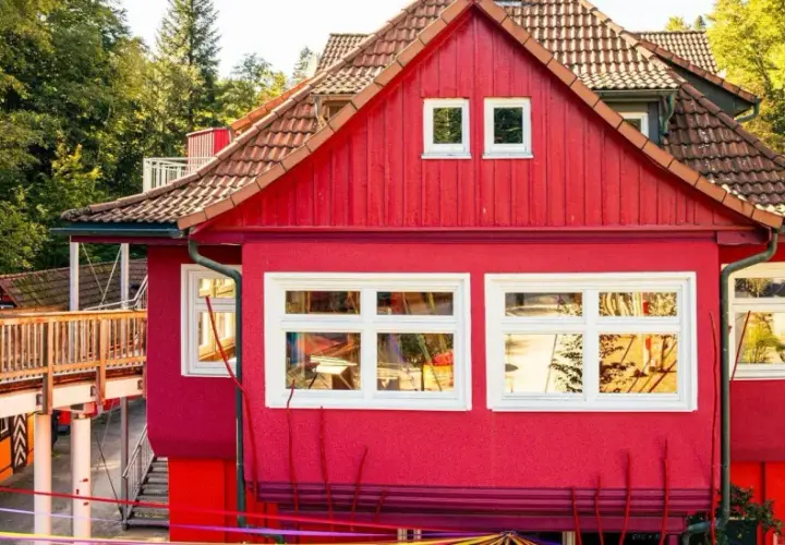 Ein leuchtend rotes Haus mit Holzbrücke und bunten Bändern. Hier gibt es Spaß für eins und alles ab welchem Alter.