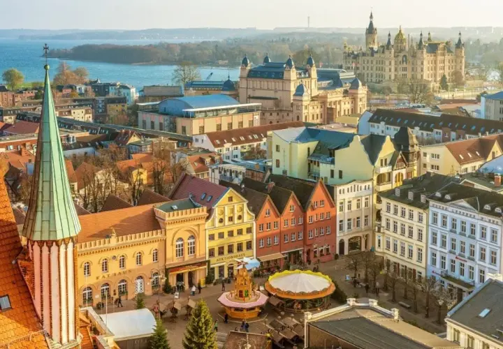 Blick über Schwerin mit Schloss, Rathaus und bunten Giebelhäusern. Entdecken Sie Schwerin Geheimtipps für Ihren nächsten Besuch!