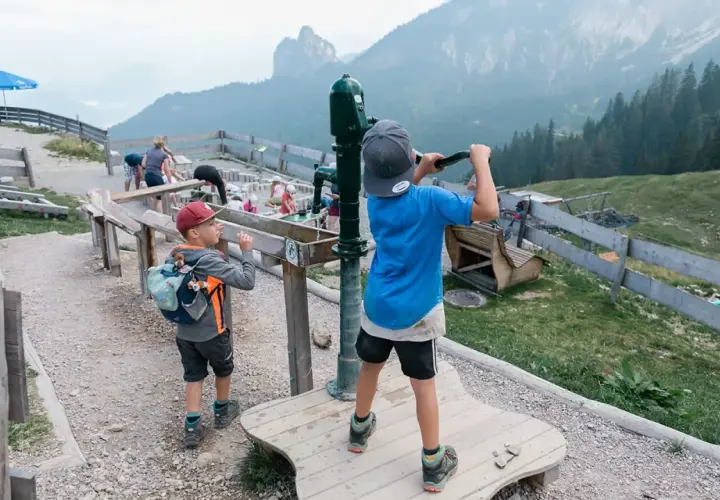 Kinder spielen am Juwelenweg Pfronten mit Bergpanorama.