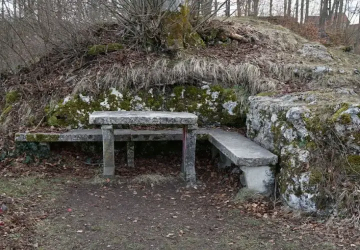 Ein Steintisch und Bänke laden zum Verweilen ein, nahe der ruine Herwartstein. Moosbewachsene Felsen und kahle Äste umgeben die Stelle.