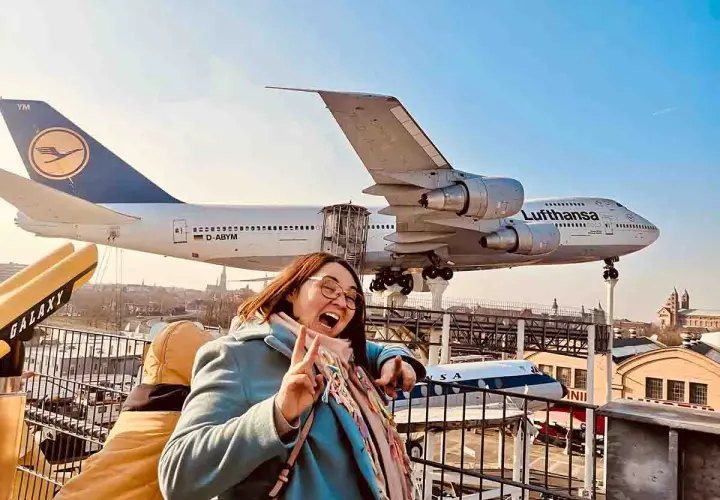 Fröhliche Frau vor einem Jumbo-Jet im Technik Museum Speyer. Ein spannender Ausflug in die Welt der Luftfahrt.