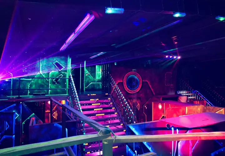 Futuristische Halle mit bunten Lichtern und Lasern. Ein aufregender Ort für Schwarzlicht Minigolf in Heidelberg.