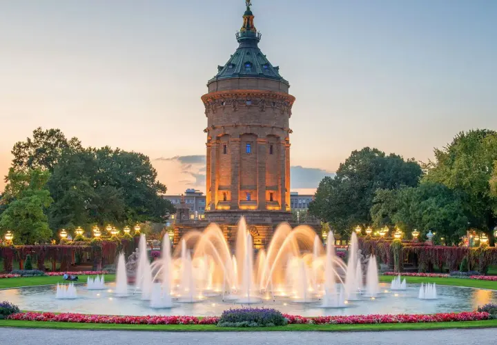 Wasserturm Mannheim mit beleuchtetem Springbrunnen im Abendlicht. Ein schöner Ort, um zu entspannen und zu sehen, was man in Mannheim machen kann.
