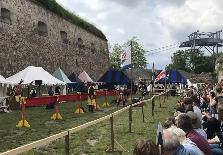 Ritterkämpfe vor der Festung Ehrenbreitstein. Ein mittelalterliches Spektakel mit Zelten und Zuschauern, das an einen historischen Spielplatz erinnert.