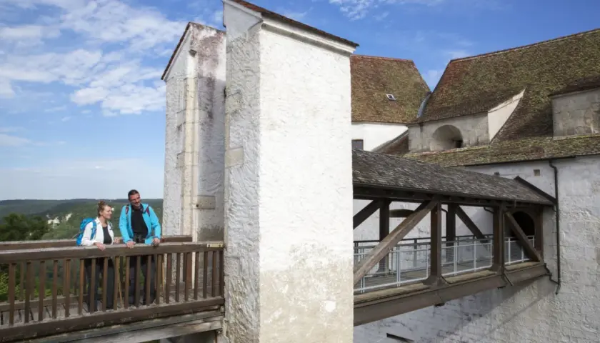 Ein Paar genießt den Ausblick von der Holzbrücke der Burg Wildenstein im Donautal.