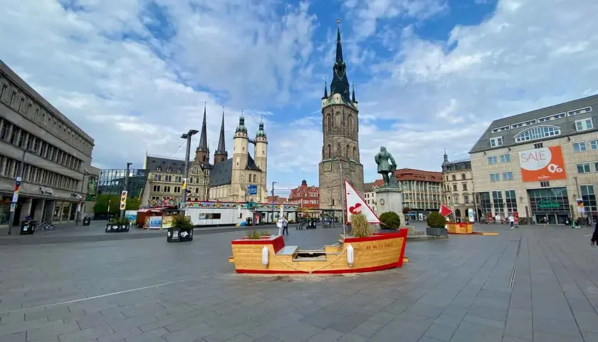Marktplatz in Halle mit historischer Architektur und einer Boots-Installation. Hier kann man viel entdecken und erleben!