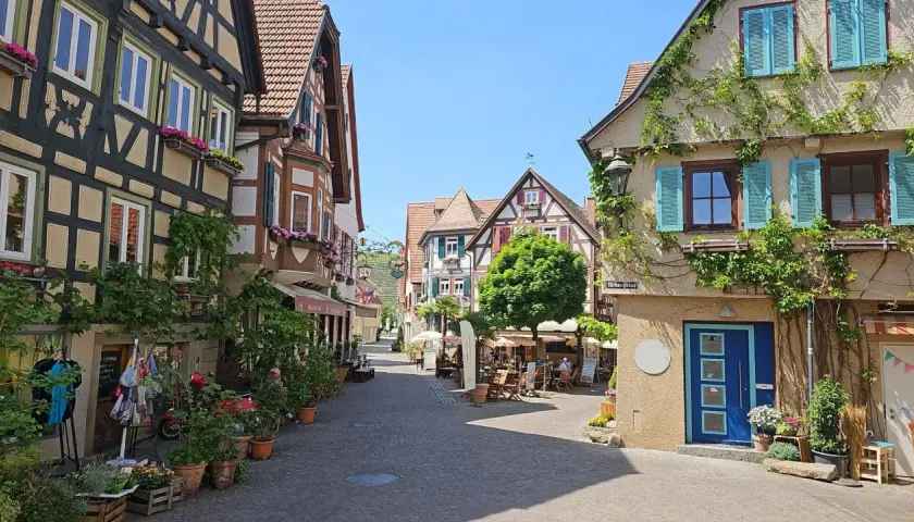 Idyllische Gasse in Besigheim, perfekt zum Wandern. Fachwerkhäuser mit Blumen geschmückt, laden zum Verweilen ein.