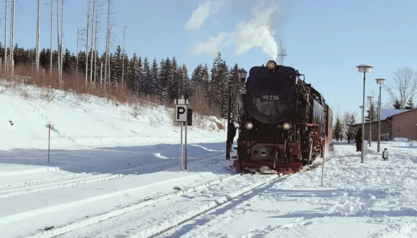 Dampflok 99 236 fährt durch verschneite Landschaft. Ein tolles Erlebnis für Wernigerode mit Kindern im Winter.