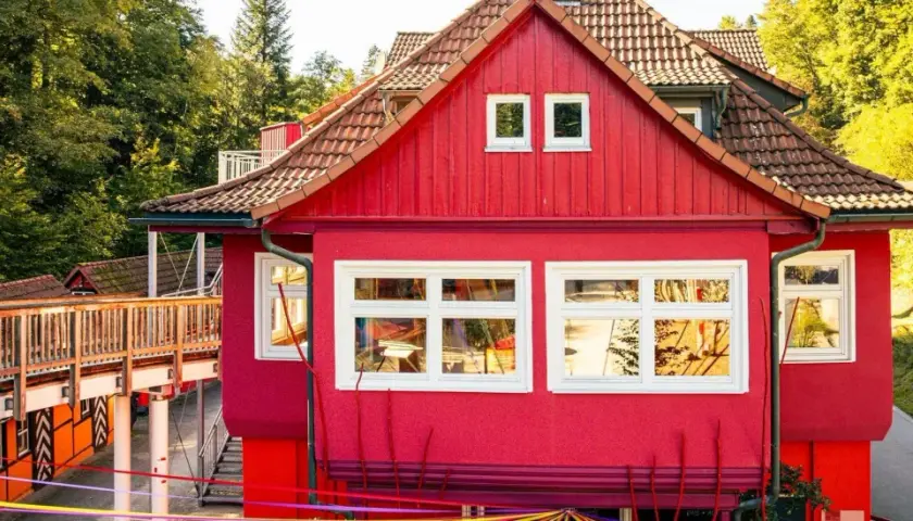 Ein leuchtend rotes Haus mit Holzbrücke und bunten Bändern. Hier gibt es Spaß für eins und alles ab welchem Alter.