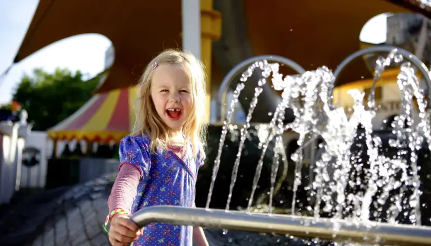 Ein fröhliches Mädchen spielt am Wasserspielplatz im Europa-Park.
