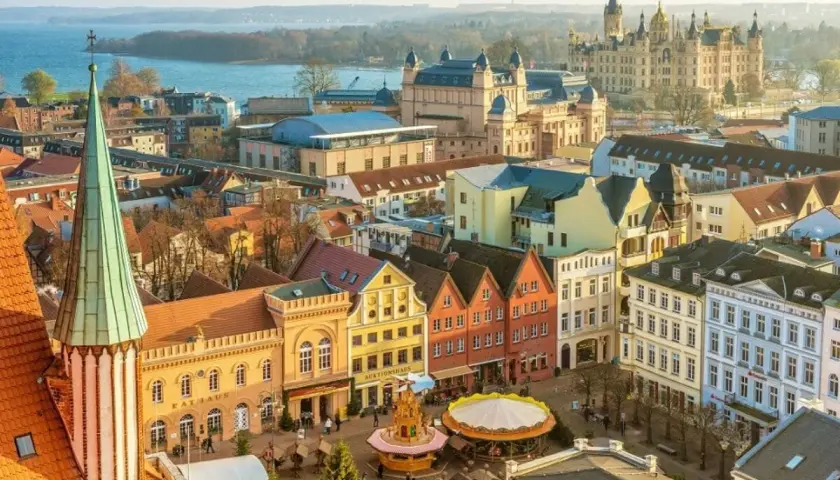 Blick über Schwerin mit Schloss, Rathaus und bunten Giebelhäusern. Entdecken Sie Schwerin Geheimtipps für Ihren nächsten Besuch!