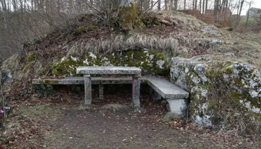 Ein Steintisch und Bänke laden zum Verweilen ein, nahe der ruine Herwartstein. Moosbewachsene Felsen und kahle Äste umgeben die Stelle.