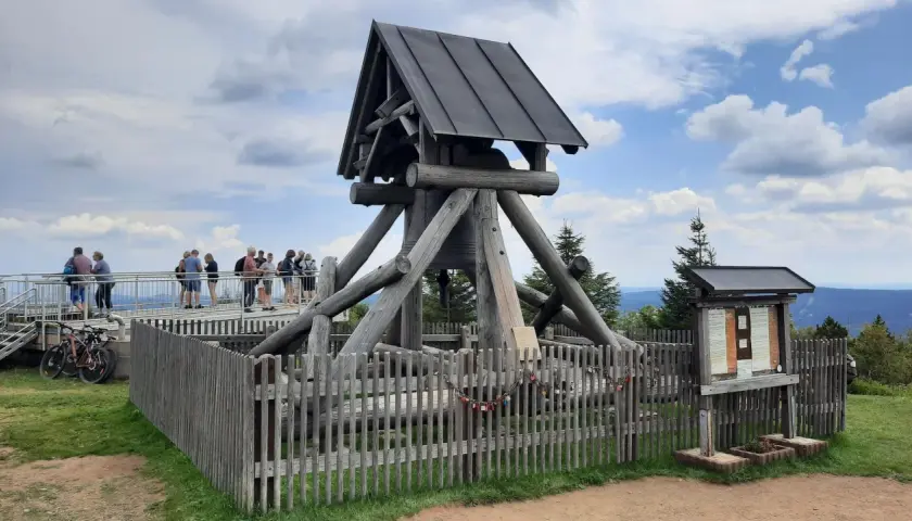 Besucher genießen Aussicht am Glockenturm, einem der vielen Ausflugsziele im Erzgebirge. Fahrräder stehen bereit für weitere Erkundungen.