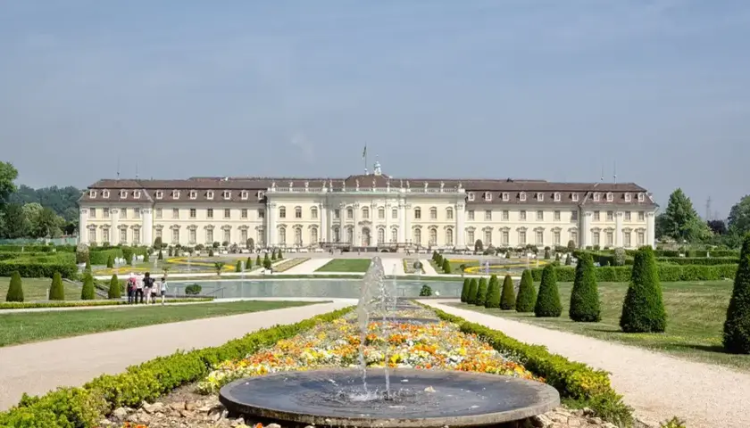 Prachtvolles Barockschloss Ludwigsburg mit symmetrischen Gärten und einem blühenden Blumenbeet vor einem Brunnen.