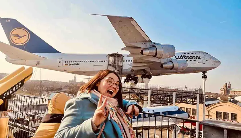 Fröhliche Frau vor einem Jumbo-Jet im Technik Museum Speyer. Ein spannender Ausflug in die Welt der Luftfahrt.