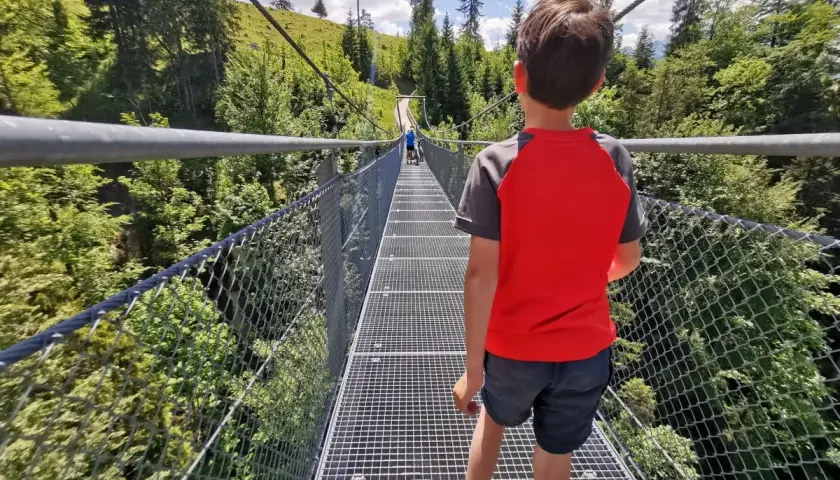 Junge auf Hängebrücke, ein Abenteuer bei einer leichten Wanderung mit Kindern in Bayern.