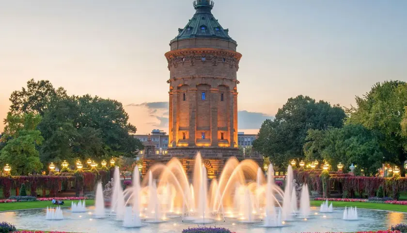 Wasserturm Mannheim mit beleuchtetem Springbrunnen im Abendlicht. Ein schöner Ort, um zu entspannen und zu sehen, was man in Mannheim machen kann.
