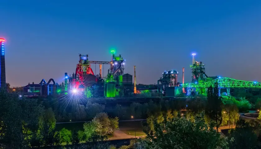 Industriepark Landschaftspark Nord in Duisburg bei Nacht, beleuchtet in bunten Farben. Ein toller Ort, um zu sehen, was man in Duisburg machen kann!