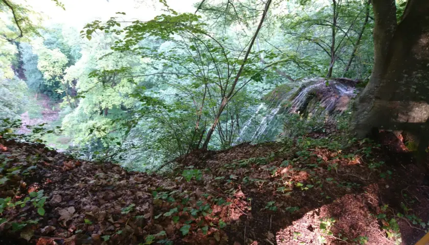 Ein Wasserfall stürzt in einem grünen Tal bei Reutlingen in die Tiefe. Ein schöner Ort zum Wandern.