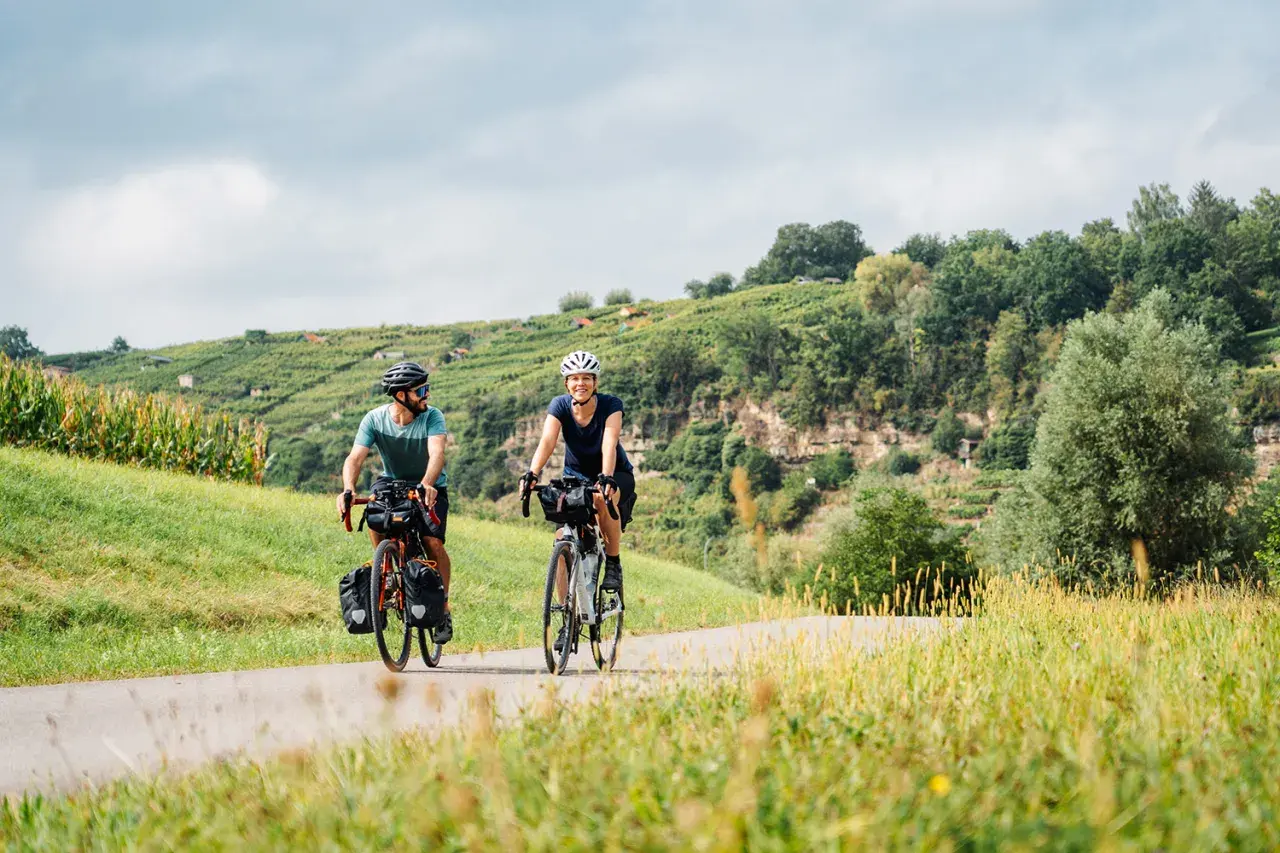 Zwei Radfahrer auf Tour zwischen Ludwigsburg und Stuttgart, vorbei an Weinbergen und Feldern.