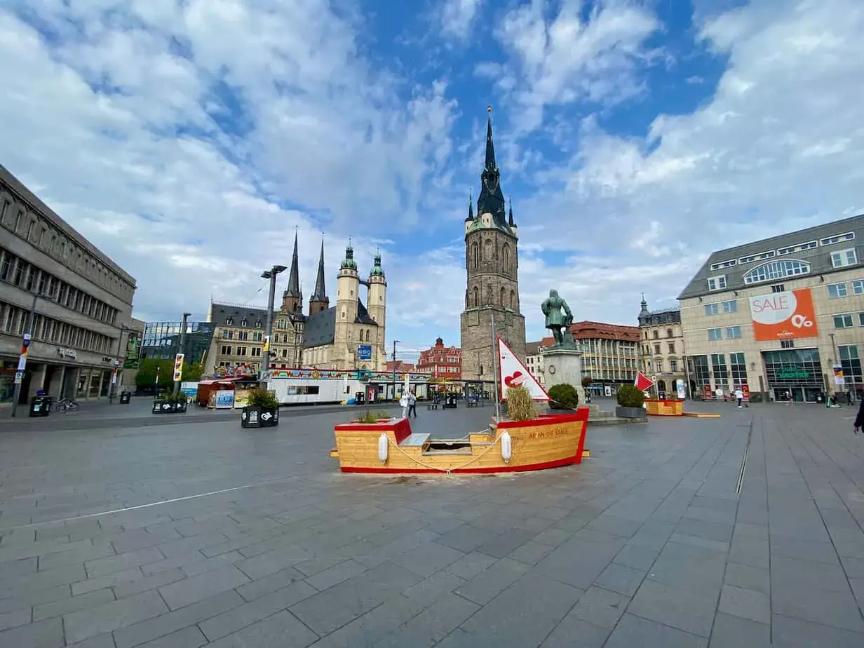 Marktplatz in Halle mit historischer Architektur und einer Boots-Installation. Hier kann man viel entdecken und erleben!