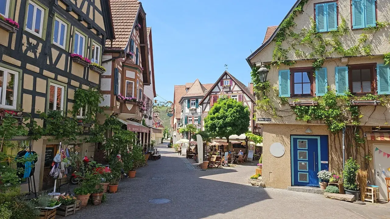 Idyllische Gasse in Besigheim, perfekt zum Wandern. Fachwerkhäuser mit Blumen geschmückt, laden zum Verweilen ein.