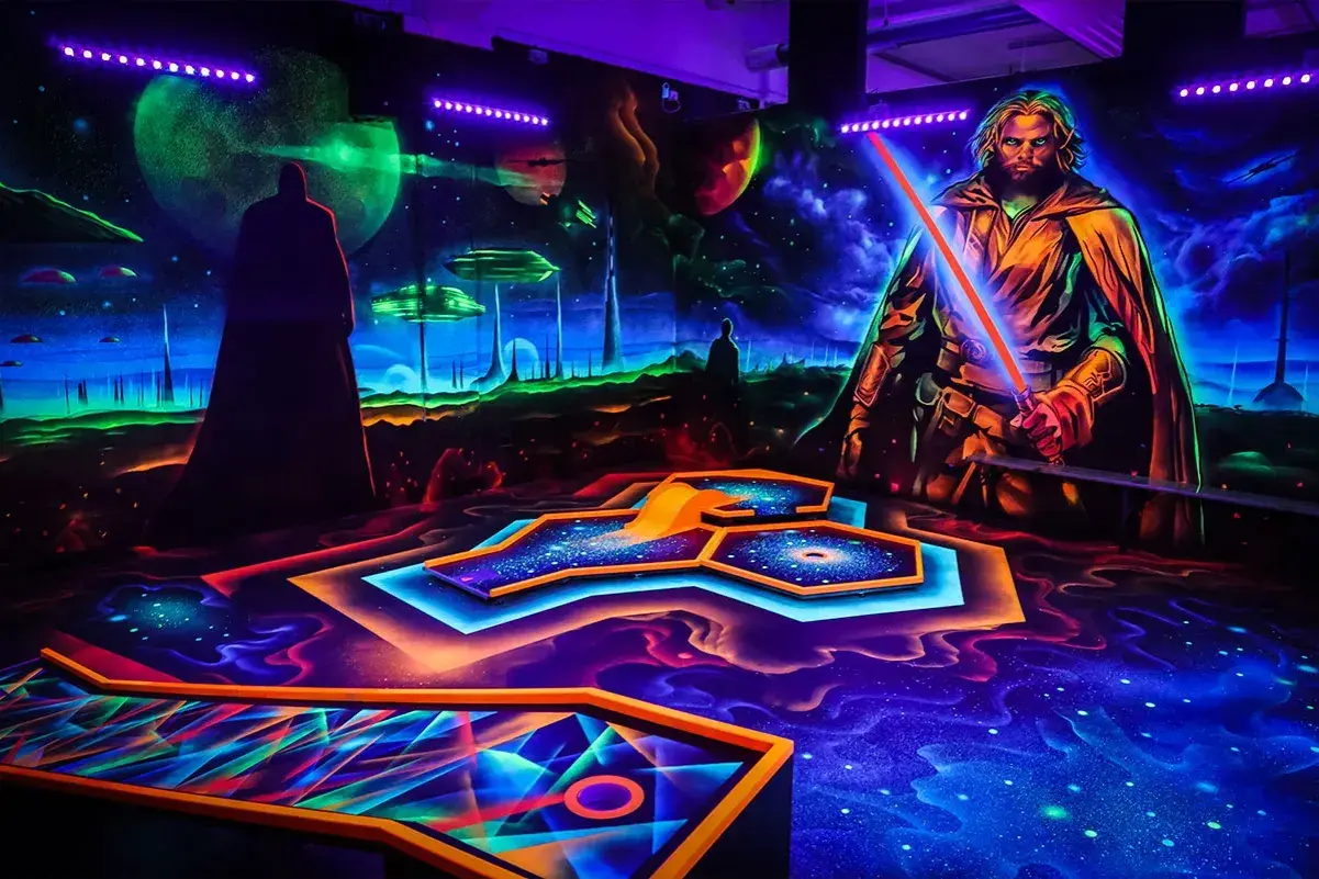 Galaktisches indoor schwarzlicht minigolf mit leuchtenden Bahnen und Weltraum-Kulisse. Ein Jedi mit rotem Lichtschwert wacht über das Spiel.