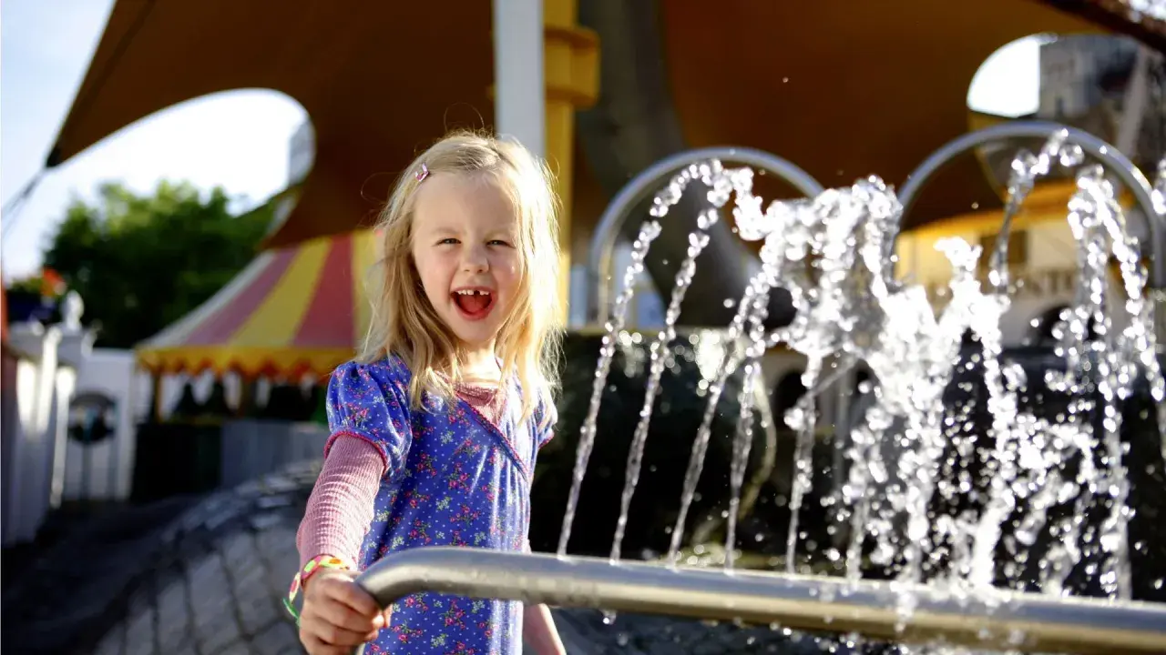 Ein fröhliches Mädchen spielt am Wasserspielplatz im Europa-Park.