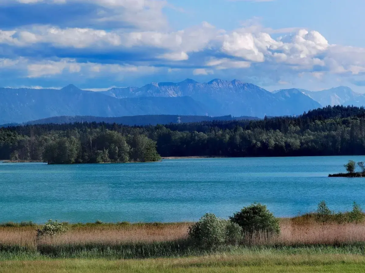 Türkisblaue Osterseen laden zum Baden ein, umrahmt von grünen Wäldern und majestätischen Alpen.