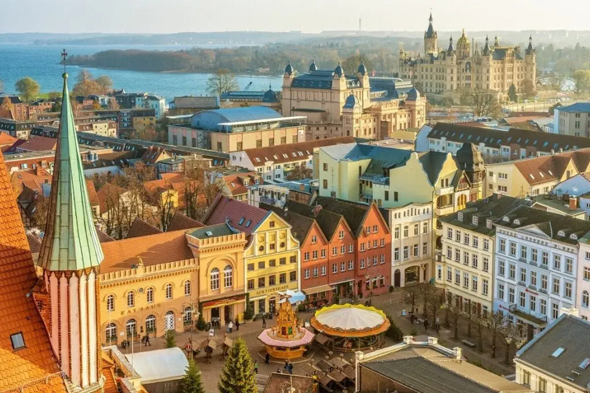 Blick über Schwerin mit Schloss, Rathaus und bunten Giebelhäusern. Entdecken Sie Schwerin Geheimtipps für Ihren nächsten Besuch!