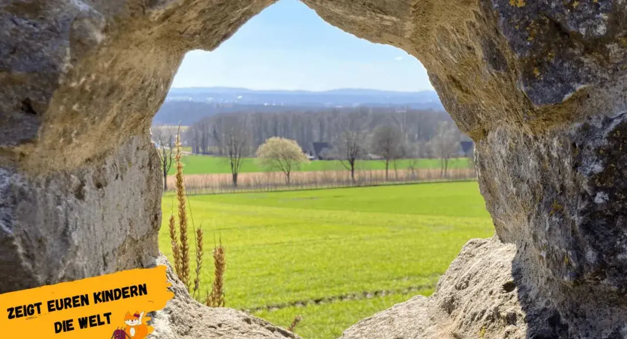 Blick durch eine Felsöffnung auf grüne Felder und Bäume. Ein tolles Motiv für Ausflugsziele Niederrhein, um Kindern die Welt zu zeigen.