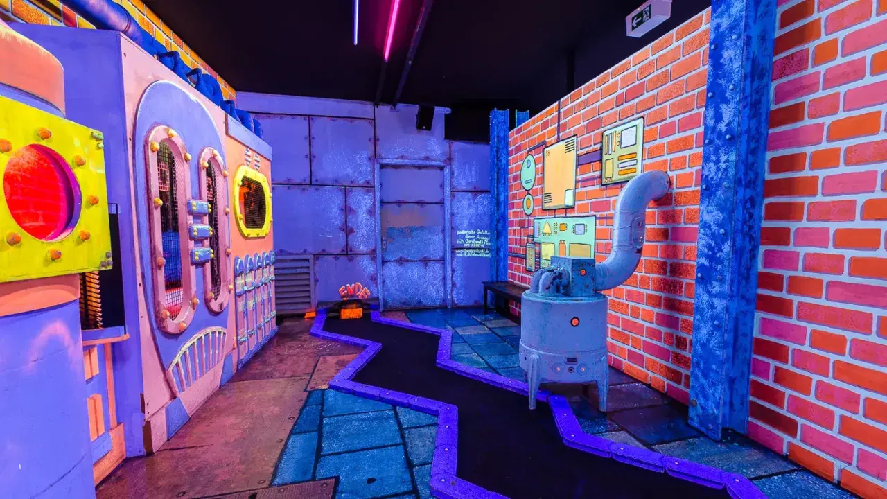 Bunte Minigolfanlage in Hamburg abends mit Kindern. Ein verrückter Parcours mit leuchtenden Farben und industriellem Design.